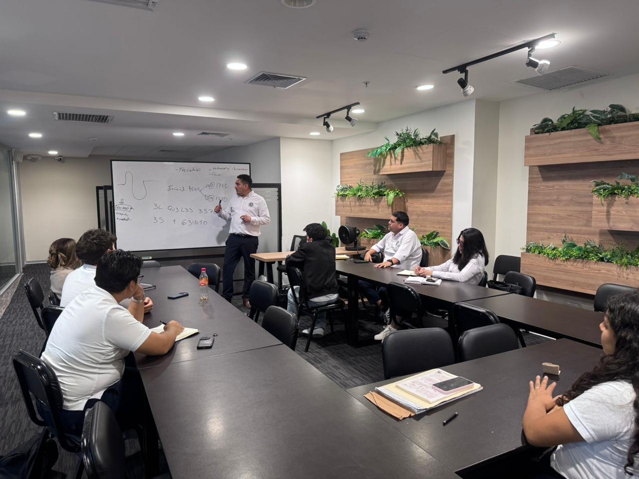 Equipo de TCI en una sesión de capacitación con su instructor en la sala de reuniones